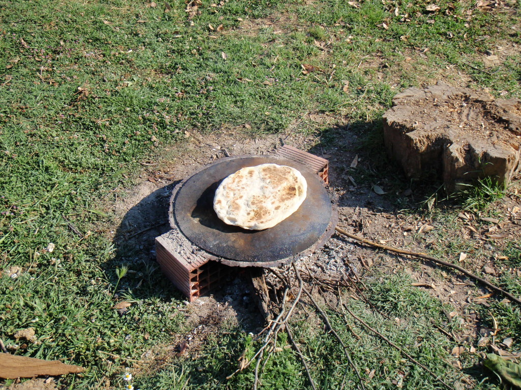 Baking bread on an open fire with a steel plate.