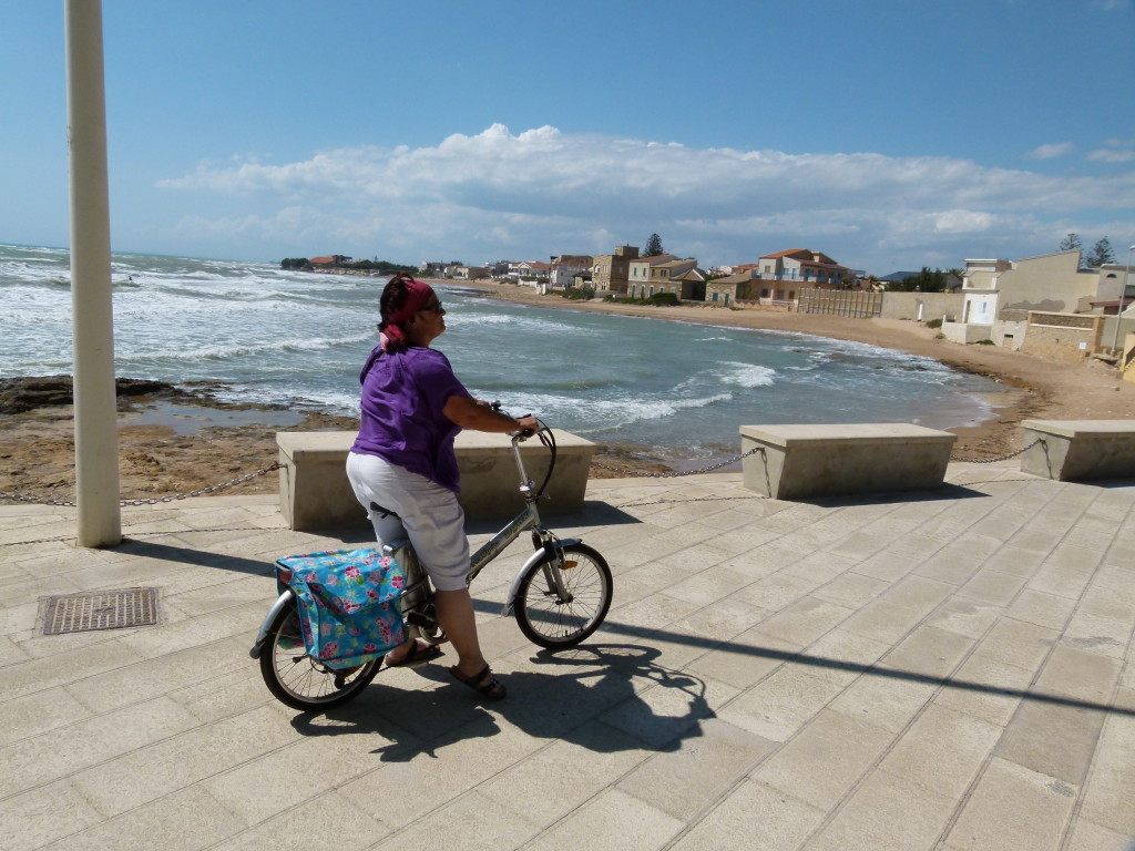 Jenny on her bike at Punta Secca. It was a windy day and not beach weather.