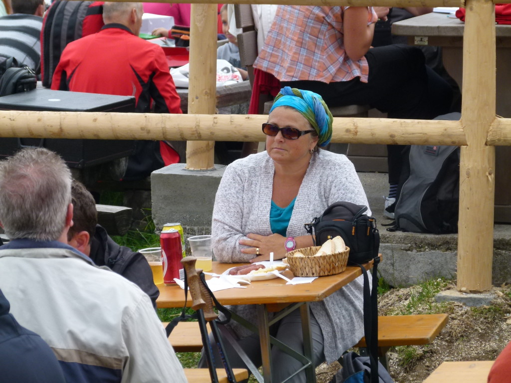 There she is drinking beer and eating sausage and potato salad. 