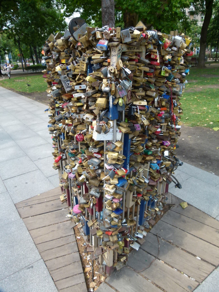 a locksmiths dream, padlocks that pledge love on a metal tree protector