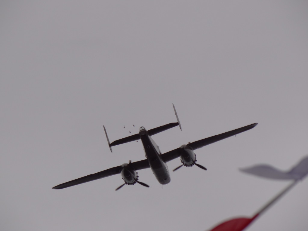 A B25 Mitchell Bomber flies over and dropped bread rolls in plastic bags.