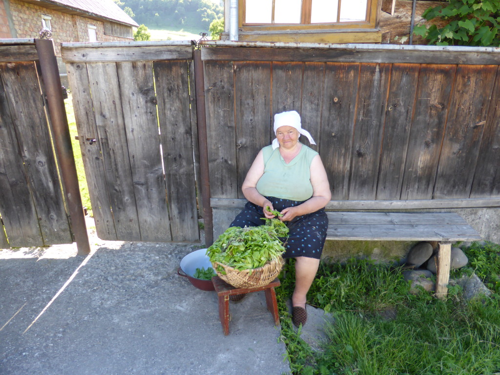 Preparing vegetables out the front of her house. Watching the world go by .