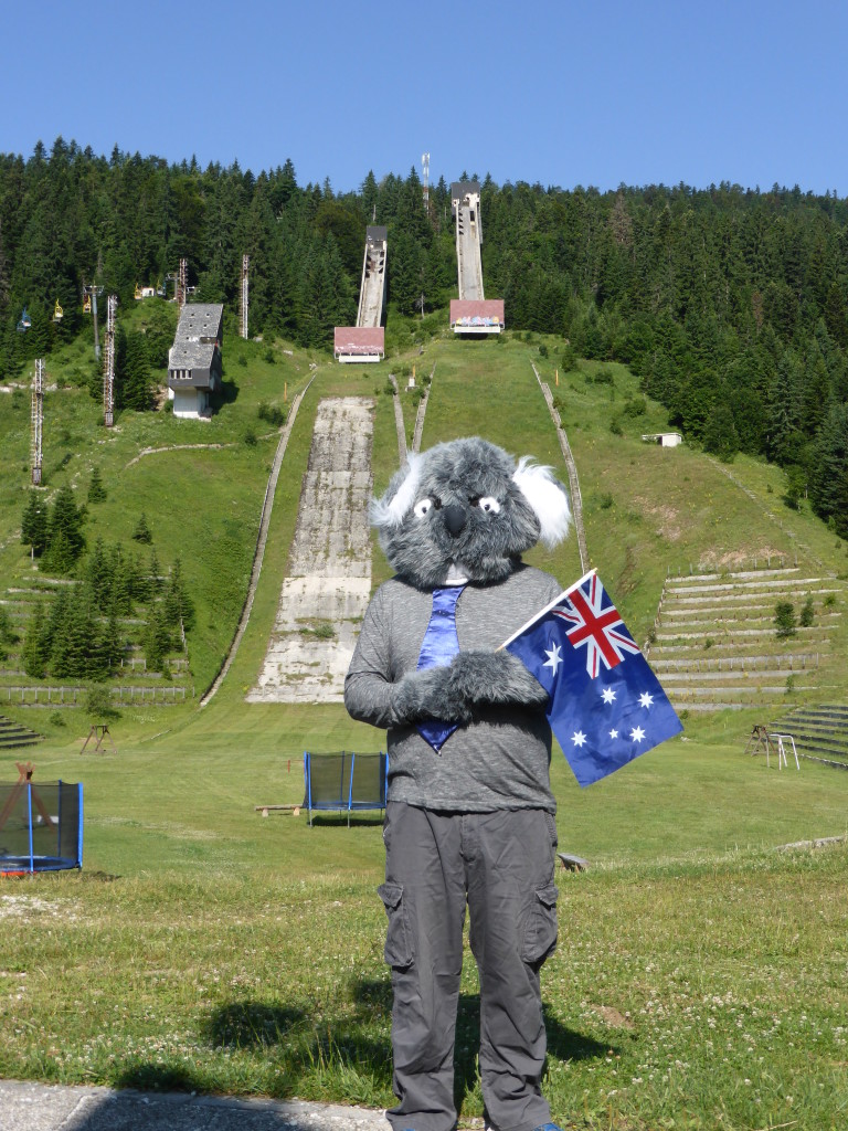 The Koala standing in front of the ski ramps. 